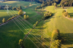 Stromtrasse, die durch Wald- und Wiesenlandschaft führt