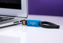 Ein Laptop, daneben USB-Stick mit Aufschrift Logo