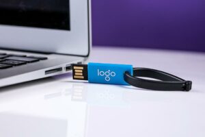 Ein Laptop, daneben USB-Stick mit Aufschrift Logo