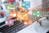 Ein Laptop und ein Einkaufswagen, daneben befinden sich Online Shopping and Social Media Ikons
