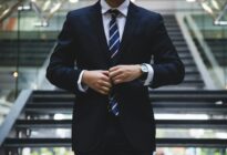 Geschäftsmann ohne Kopf knüpft Anzug zu