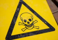 Gelbes Schild mit schwarzem Totenkopf zur Warnung giftiger Stoffe