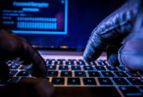 Hackerhandschuhe auf Computertastatur