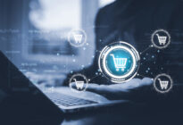 Hände auf Computertastatur, danben befinden sich Warenkörbe für Onlineprodukte